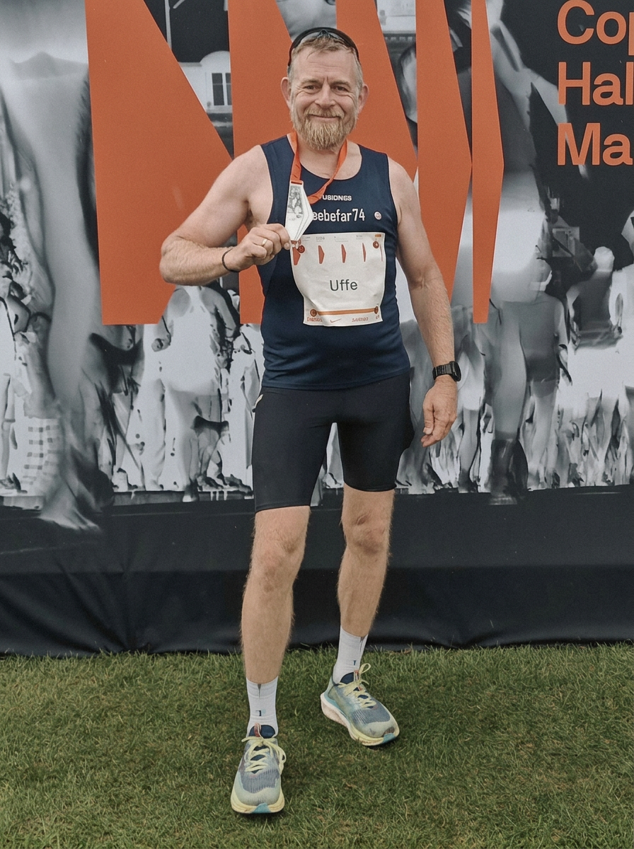 Runner holding up a medal after Copenhagen Half Marathon