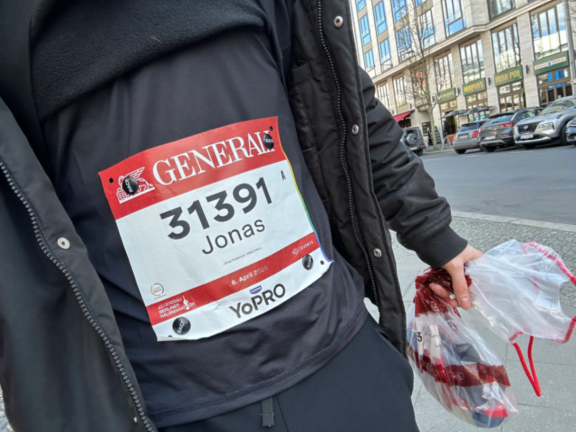 A Berlin Half Marathon race bib for runner Jonas, attached to a black jacket with magnets instead of safety pins
