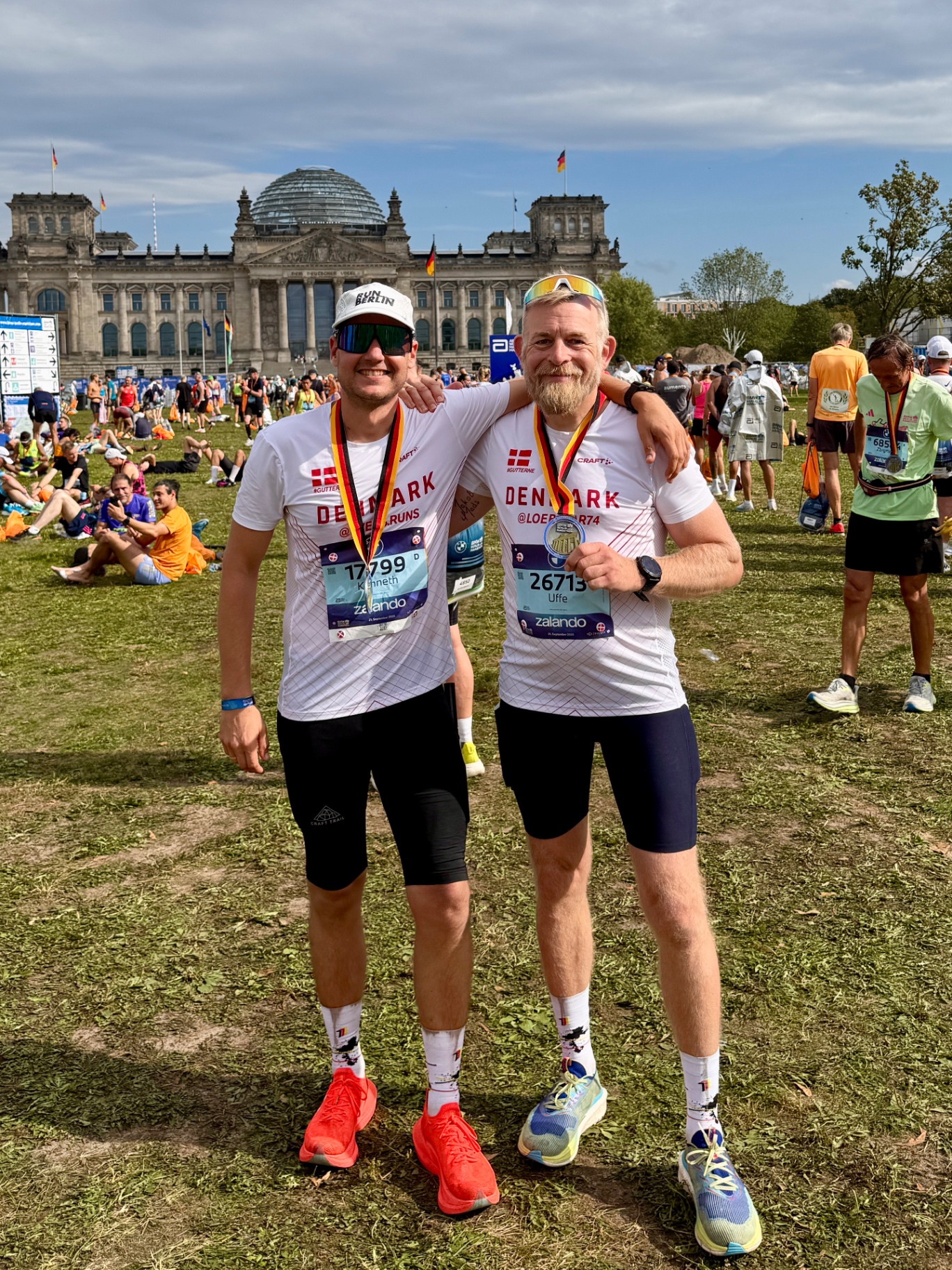 Two runners with finisher medals in front of the Reichstag at the Berlin Marathon